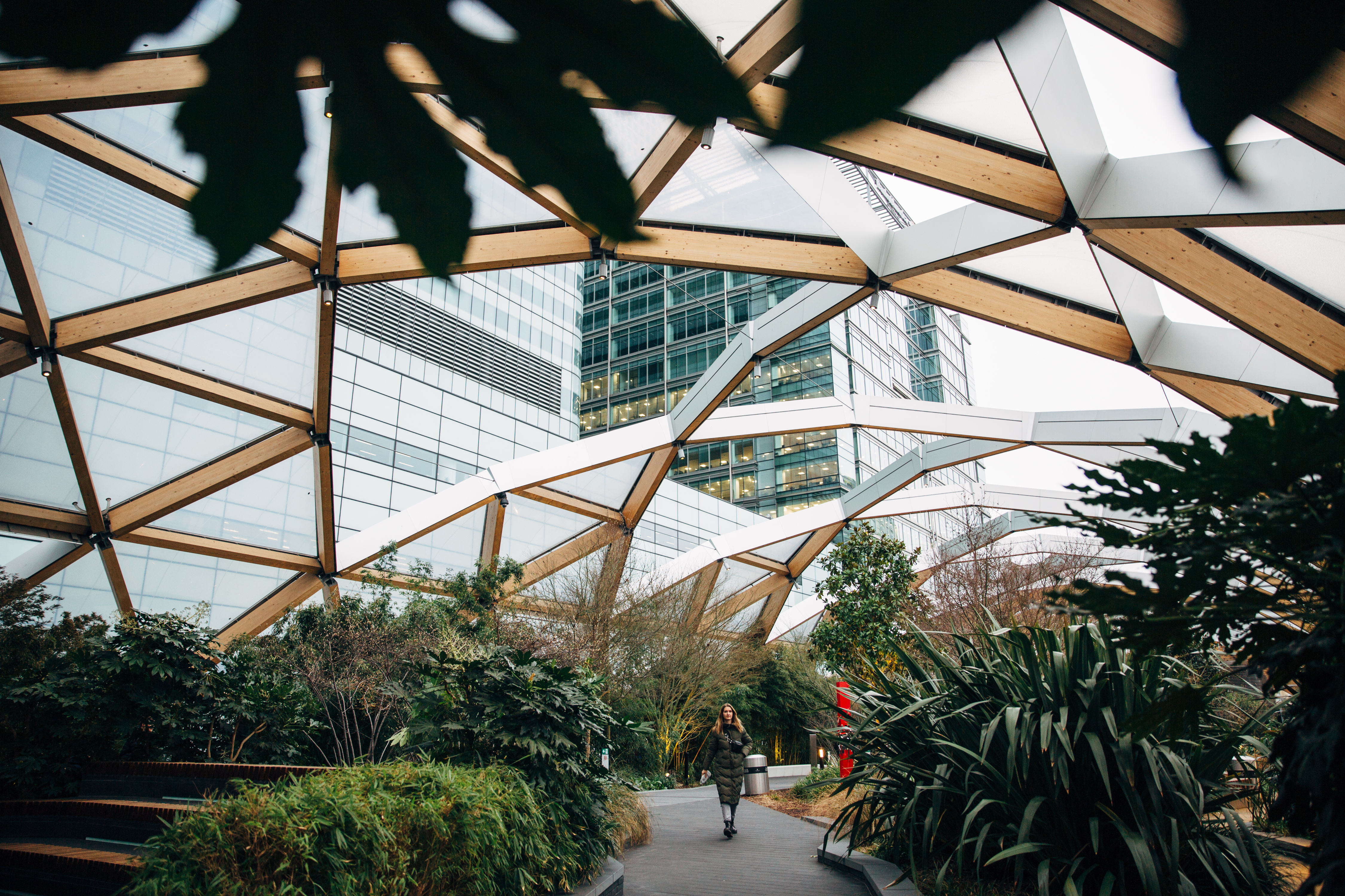 Woman in winter coat walking in hidden location in roof garden