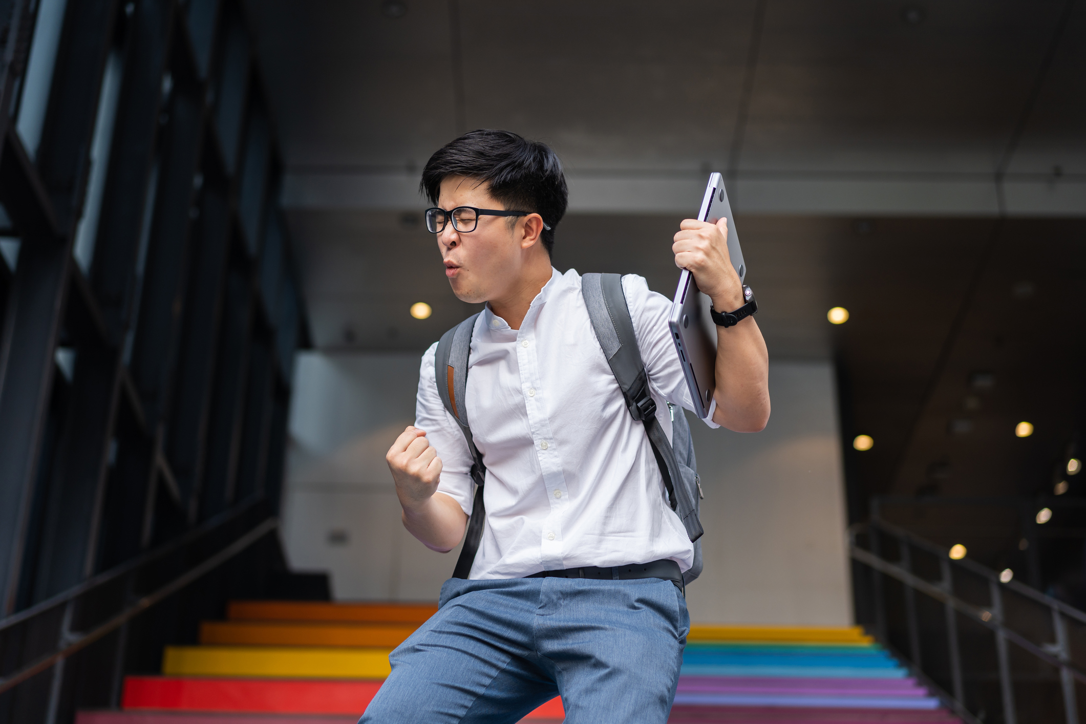 Portrait of success Asian young businessman arm raised