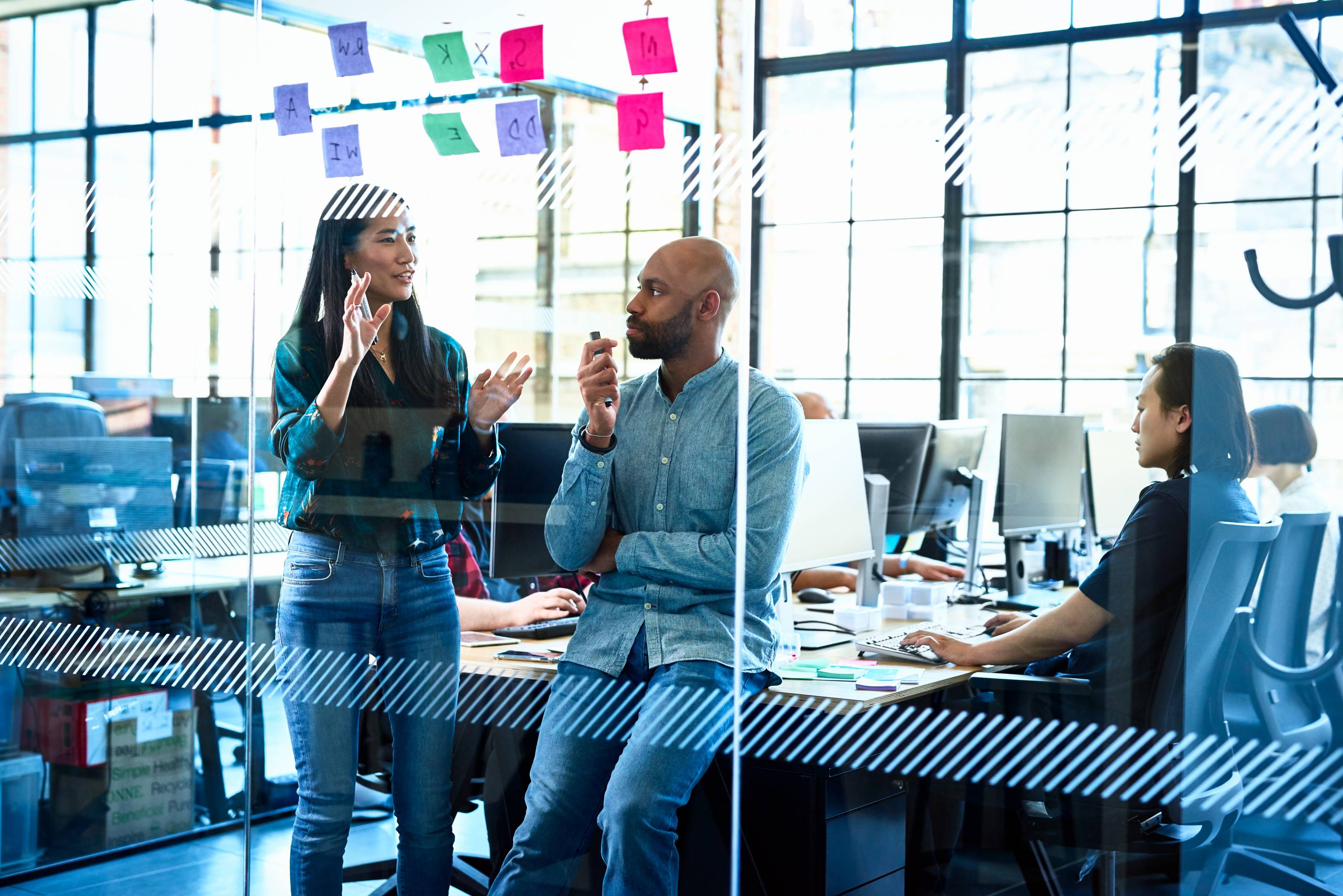 Confident Chinese woman talking to colleague in office